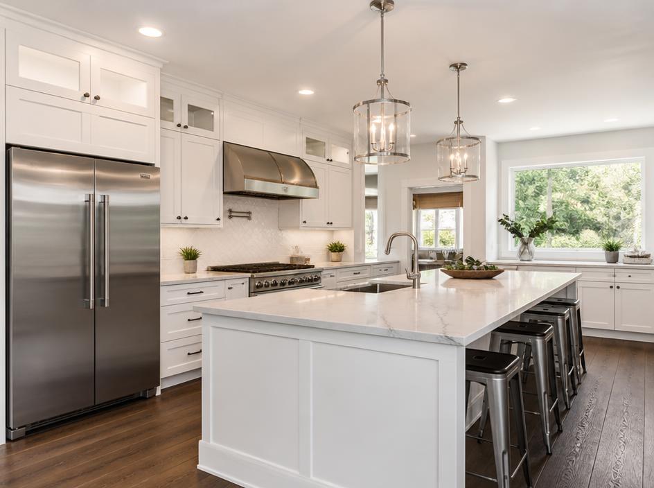 Completed modern kitchen remodel with white cabinetry and marble countertops